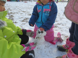 可愛い雪だるまができました。固まった雪玉に頭がのらず友だち協力して完成です。